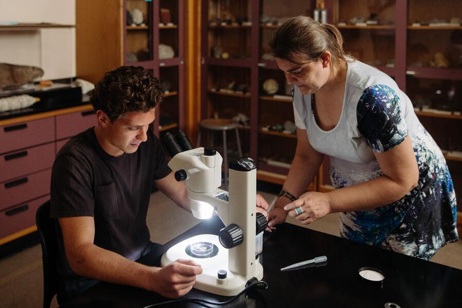 一位生物学学生在实验室里使用显微镜